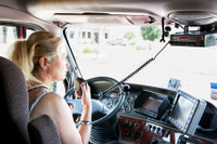 Blonde woman truck driver talking on her radio.